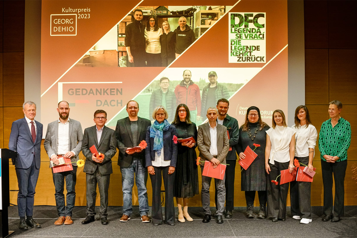 Der Moment der Preisverleihung an die Autoren des Films »DFC. Legenda se vrací - Die Legende kehrt zurück« (links) und die sechs Mitglieder des »Zentrum Gedankendach« (rechts). Die Preise überreichte Christiane Hoffmann, Erste Stellvertretende Sprecherin der Bundesregierung (in der Mitte). Ganz außen die Vertreter des Deutschen Kulturforums östliches Europa, Harald Roth, Direktor (links), und Sabine Deres, Vorstandsvorsitzende (rechts), Foto: © Deutsches Kulturforum östliches Europa, 2023 • Georg Franke Der Moment der Preisverleihung an die Autoren des Films »DFC. Legenda se vrací - Die Legende kehrt zurück« (links) und die sechs Mitglieder des »Zentrum Gedankendach« (rechts). Die Preise überreichte Christiane Hoffmann, Erste Stellvertretende Sprecherin der Bundesregierung (in der Mitte). Ganz außen die Vertreter des Deutschen Kulturforums östliches Europa, Harald Roth, Direktor (links), und Sabine Deres, Vorstandsvorsitzende (rechts), Foto: © Deutsches Kulturforum östliches Europa, 2023 • Georg Franke